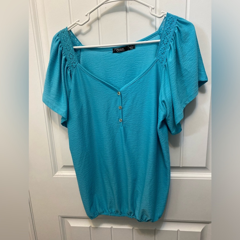 Cure blue top with sweetheart neckline. Size Medium. Eyelet shoulder detail.